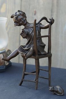 Bronzen beeld lachend meisje op stoel 2