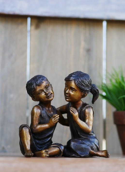 Bronzen beeld jongen en meisje zittend