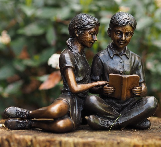 Bronzen beeld jongen en meisje lezend