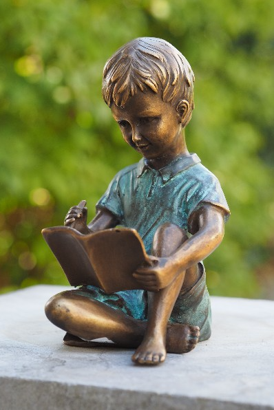 Bronzen beeld jongen met schrijfboek